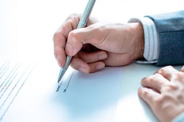 man signing post-nuptial agreement