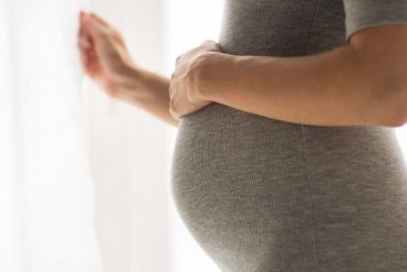 pregnant woman looking through window