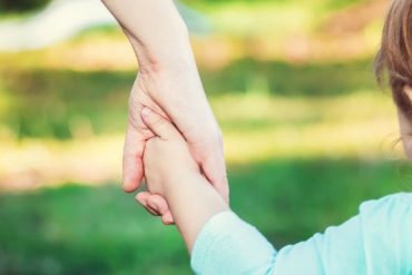 toddler girl holding hands with someone